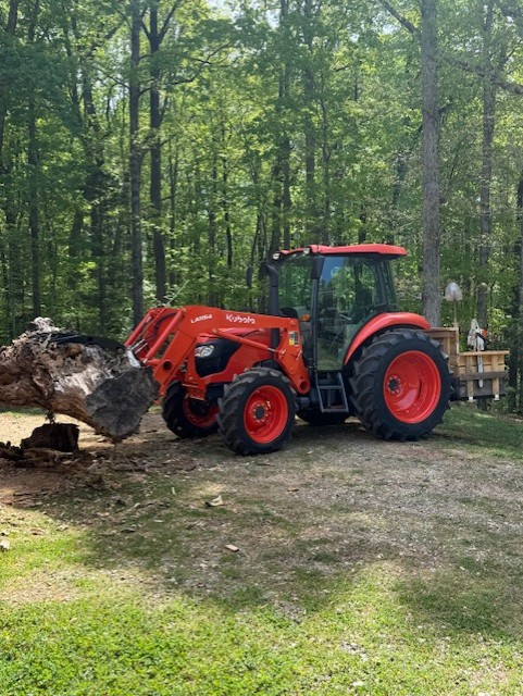 Kubota tractor moving a log on the Charlotte property