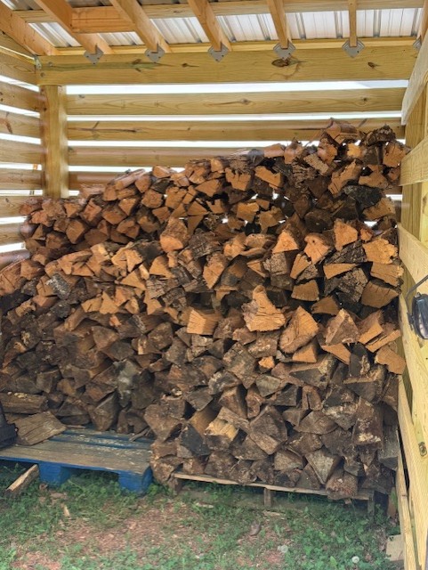 Seasoned firewood stacked inside the Charlotte wood shed
